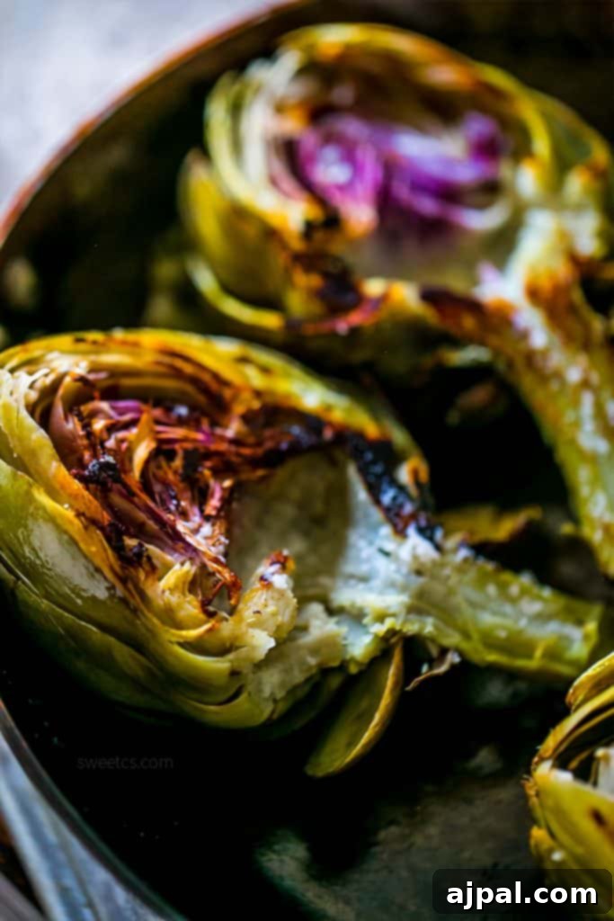 Garlic butter charred artichokes beautifully arranged on a rustic wooden table, invitingly ready to be enjoyed as a gourmet meal.