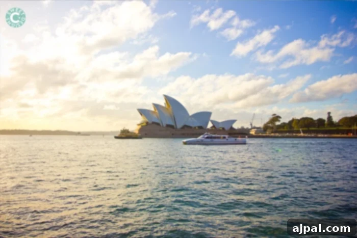 Best Travel Credit Cards for Your Next Adventure 4 The majestic Sydney Opera House illuminated at sunset, with the harbor reflecting its iconic sails.