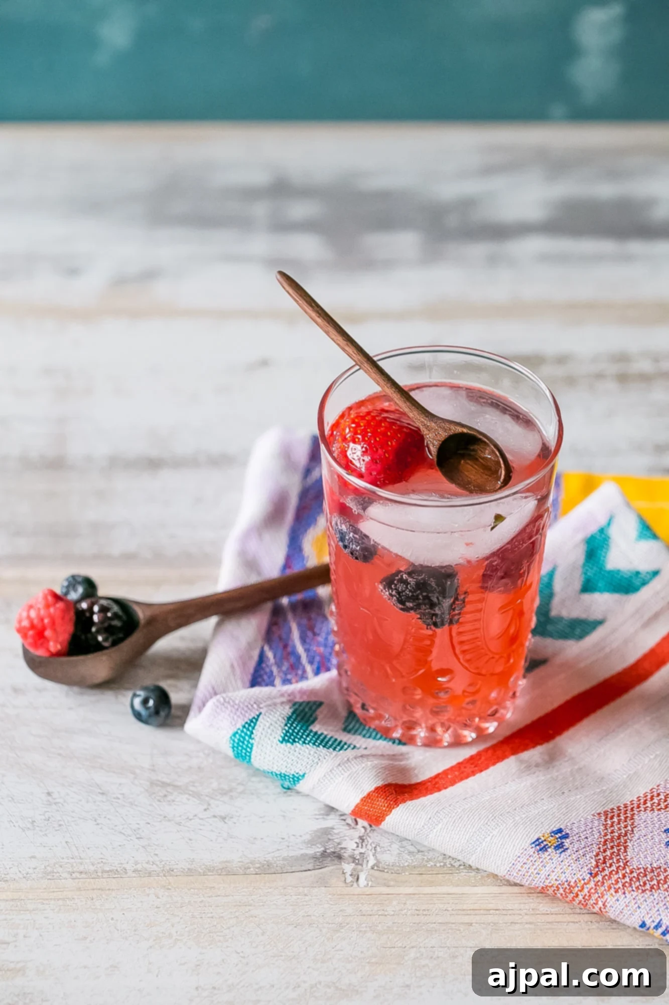 Berry Basil Garden Sparkler 2 Vibrant red lemonade filled with fresh strawberries and blackberries, garnished with basil leaves in a tall glass, perfect for a summer refresh.
