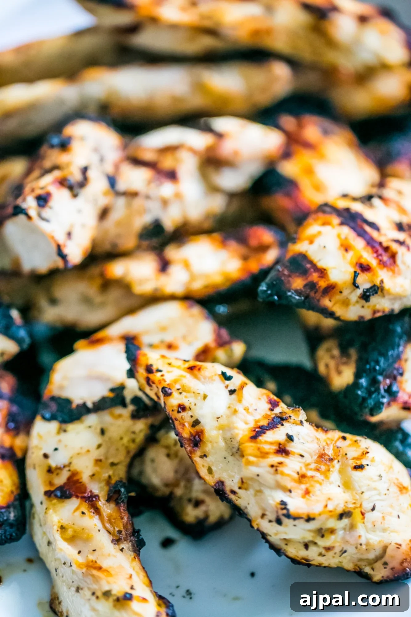 Grilled Chicken Perfection 2 Close-up picture of perfectly grilled chicken strips, golden brown with visible grill marks.