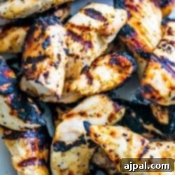 Grilled chicken strips on a white plate.