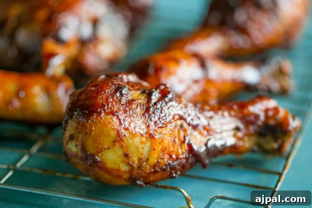 Crispy BBQ Chicken Drumsticks 3 Picture of baked bbq chicken drumsticks on wire rack, glistening with sauce