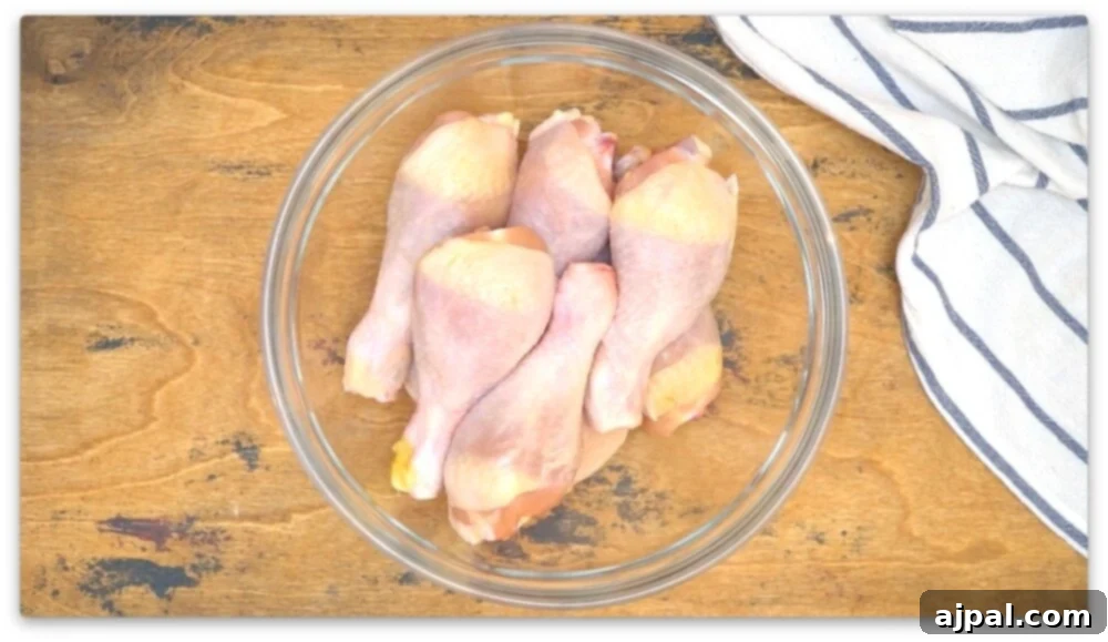 Crispy BBQ Chicken Drumsticks 5 Chicken legs cooked in an air fryer, displayed in a glass bowl on a wooden table.
