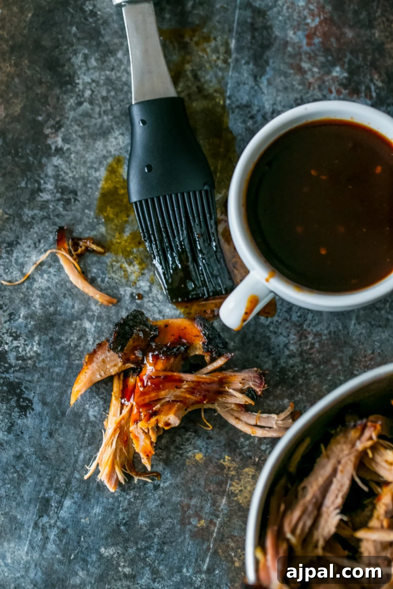 A close-up shot of a bowl of perfectly smoked pulled pork, highlighting the tender texture and delicious bark.