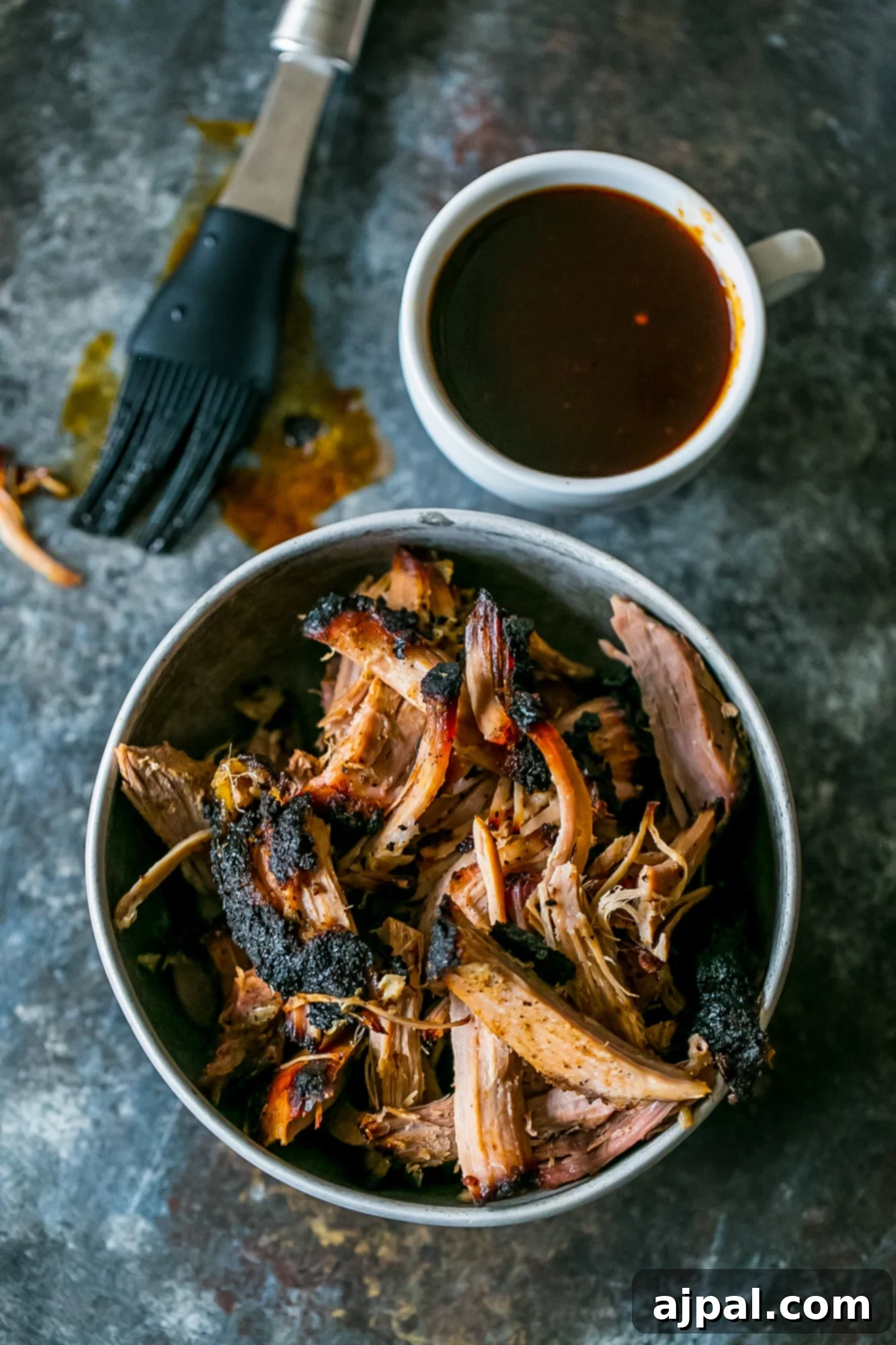 A hearty portion of smoked pulled pork, ready to be enjoyed, presented in a bowl with a fork.