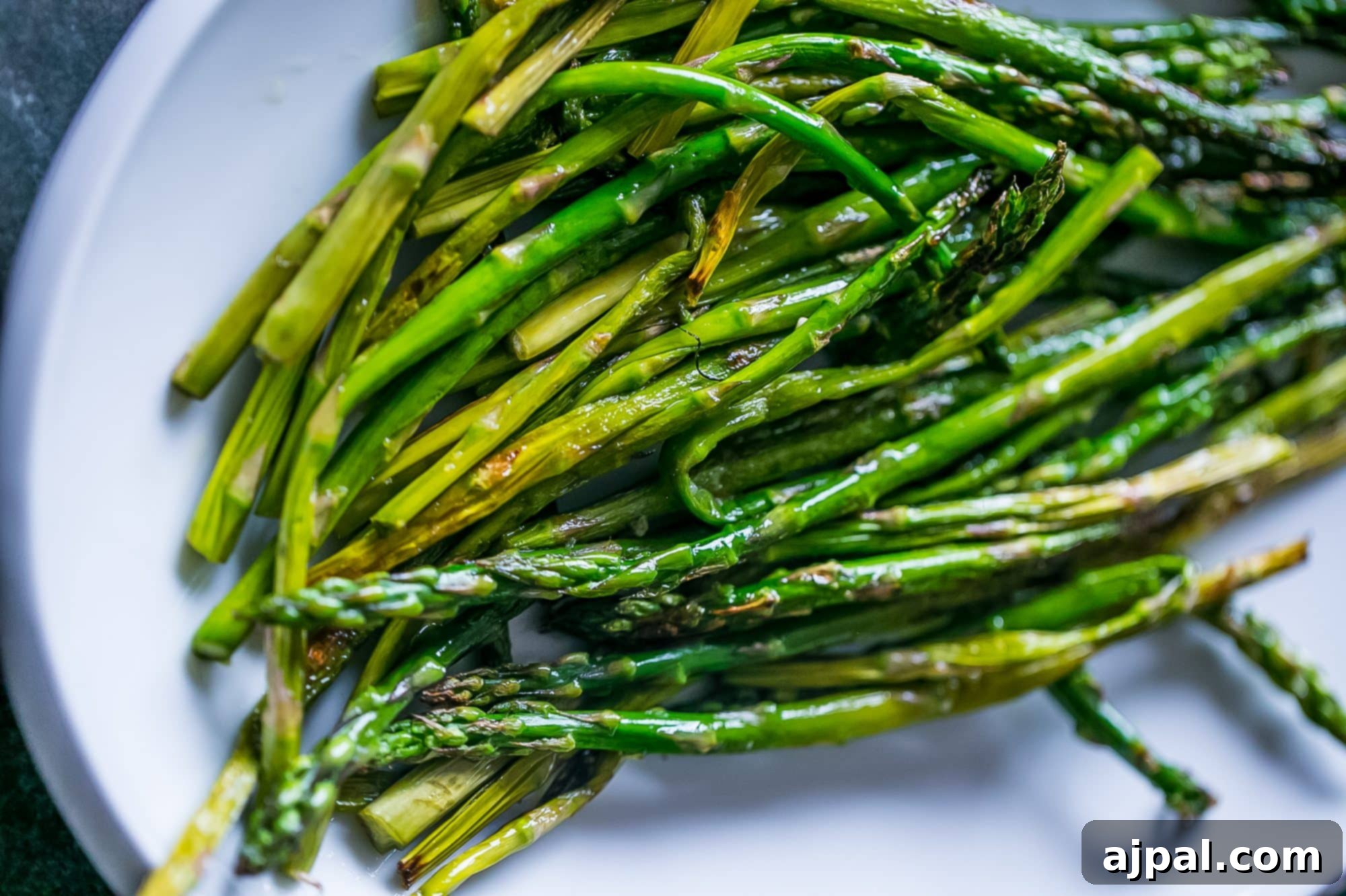 Perfectly Pan-Fried Asparagus 4 A beautifully presented serving of pan-fried asparagus on a white plate, ready to be enjoyed.
