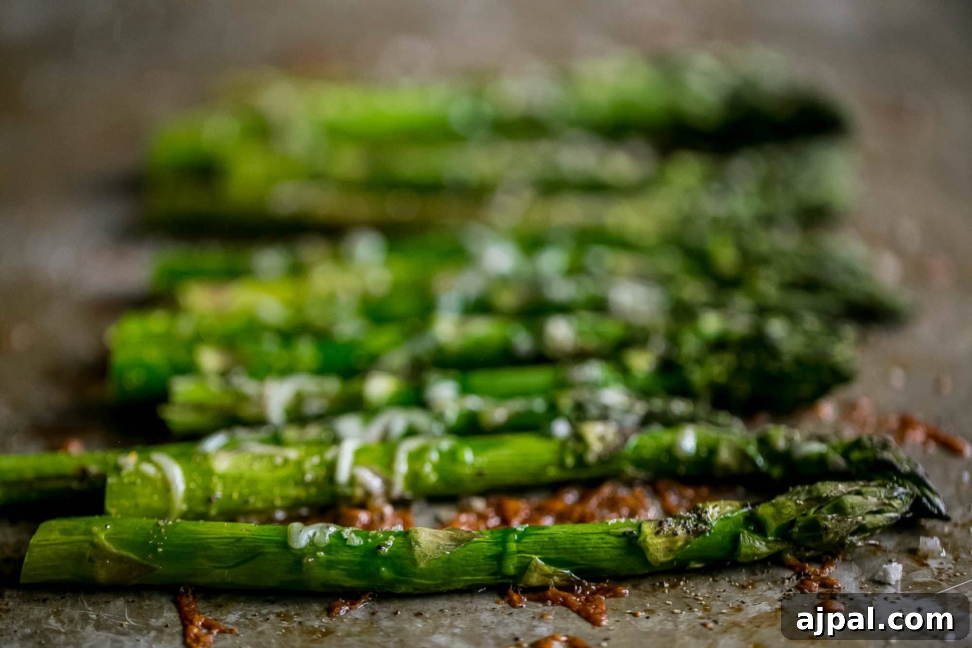 Perfectly roasted asparagus on baking sheet with melted parmesan