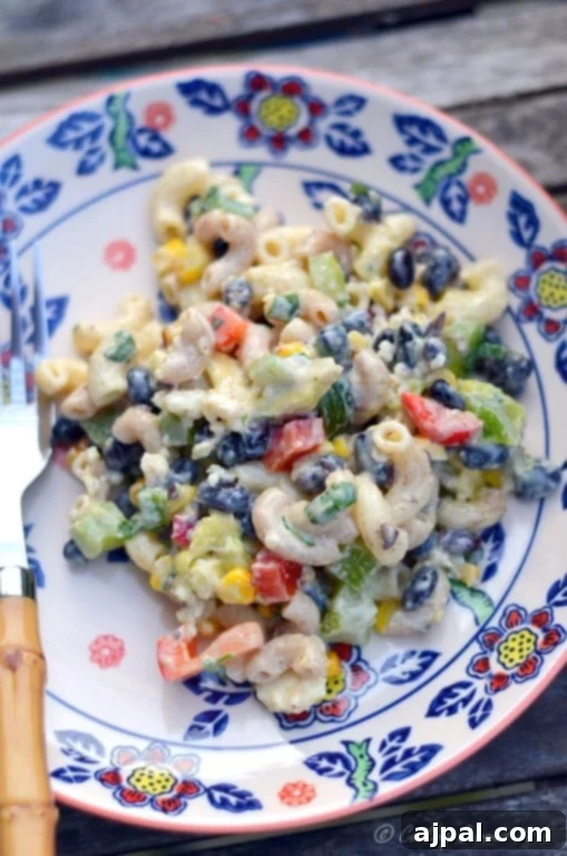 Zesty Cilantro Lime Black Bean Pasta Salad 2 Vibrant Cilantro Lime Black Bean Pasta Salad with noodles, bell peppers, corn, and creamy dressing mixed in a bowl.