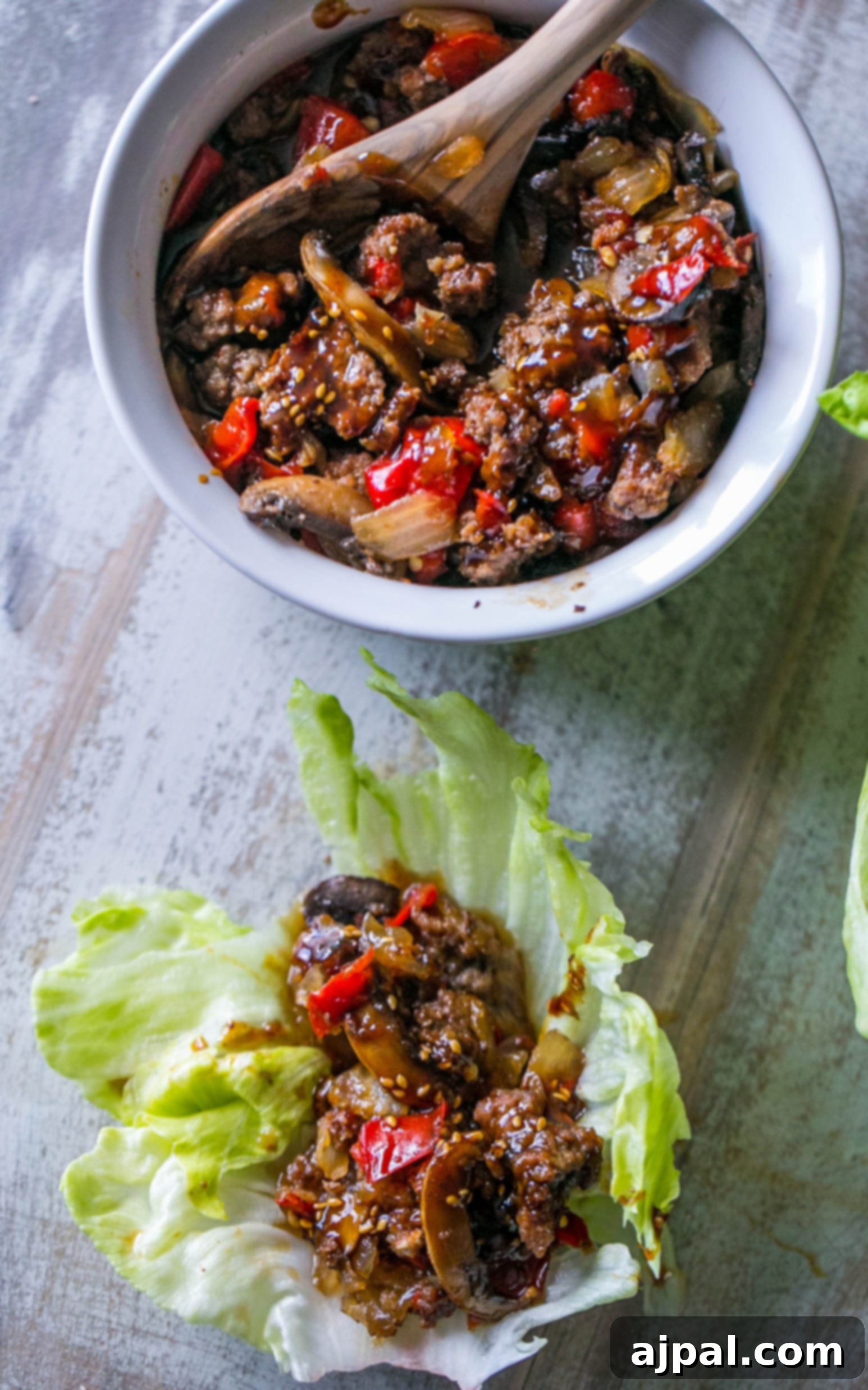 Sweet chili beef and mushrooms nestled in a crisp lettuce wrap, garnished with sesame seeds.