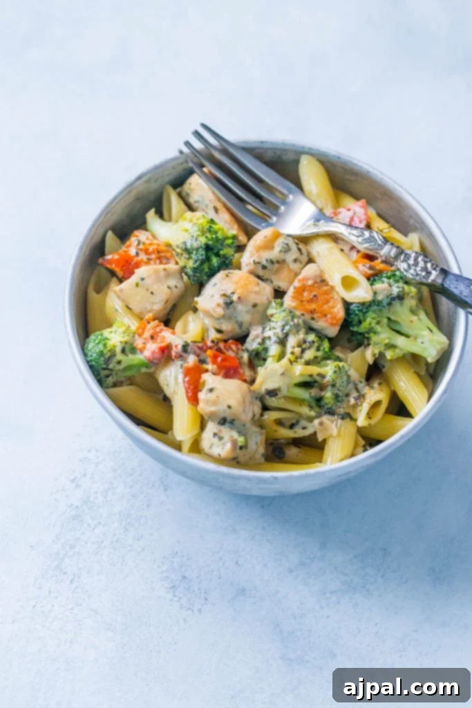 Creamy chicken and broccoli alfredo in  bowl with a fork