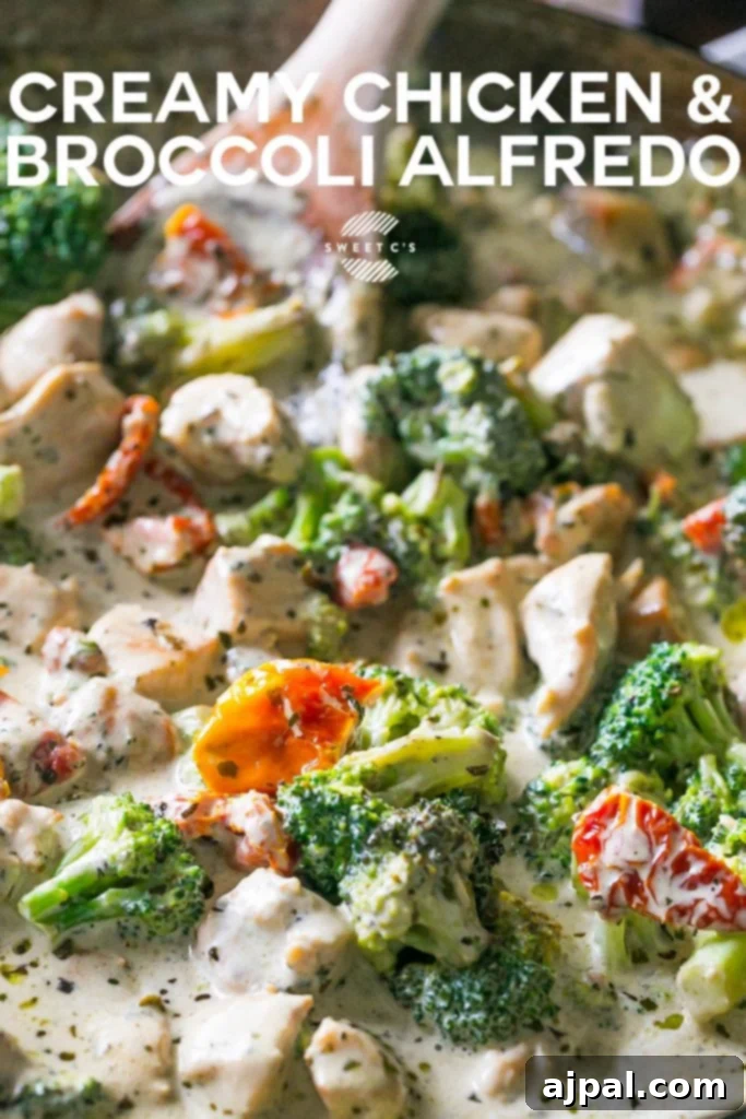 Creamy chicken broccoli alfredo in a bowl with a wooden spoon