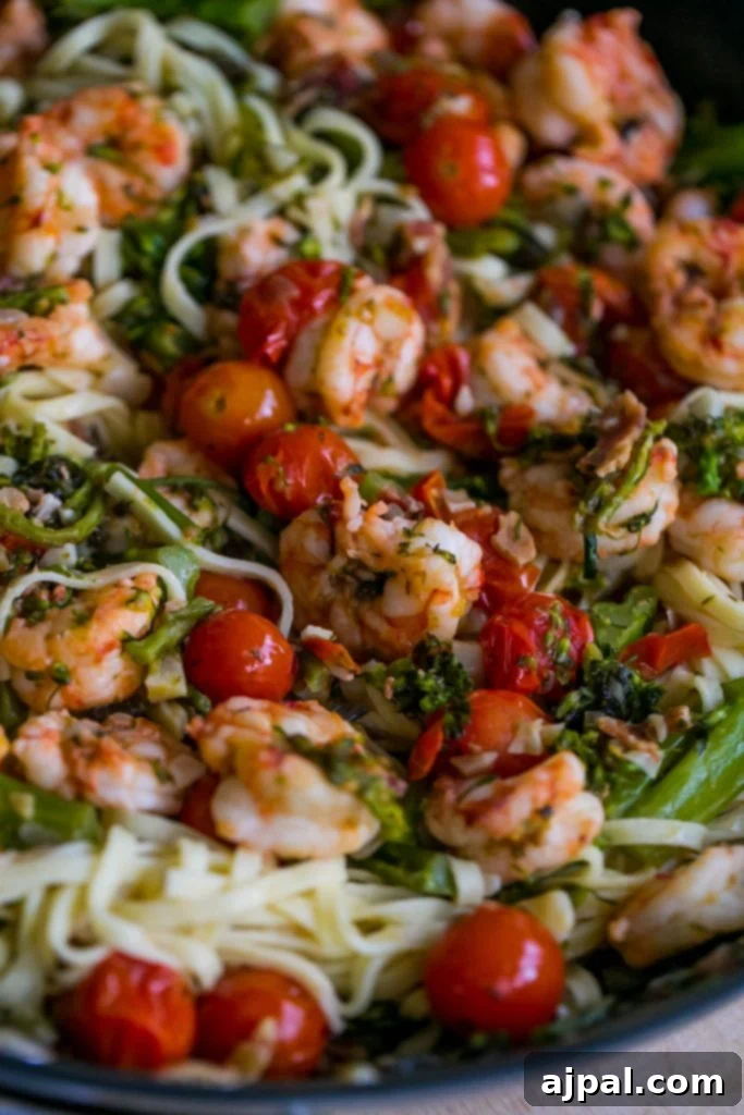 A vibrant bowl of Tuscan Shrimp Linguine with cherry tomatoes and spinach.
