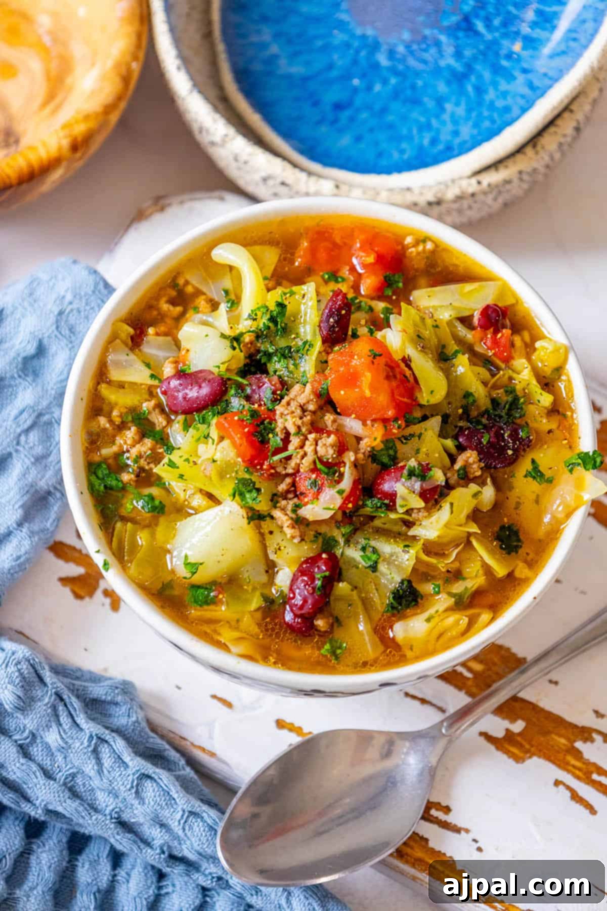 A vibrant bowl of hearty cabbage soup with ground beef, showcasing fresh ingredients.