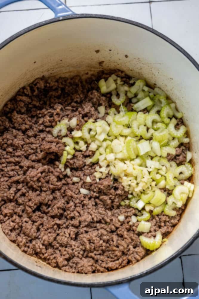 A pan with ground beef and onions, ready for the next step in making a delicious cabbage soup.