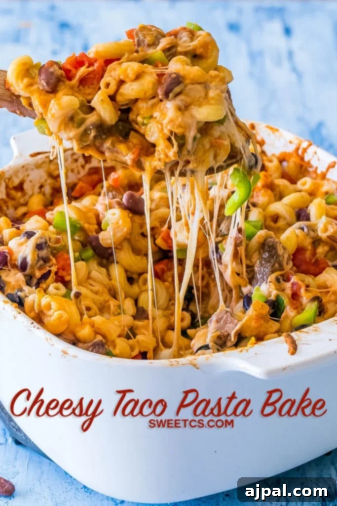 Large casserole dish filled with a bubbling Cheesy Taco Pasta Bake, showing bell peppers, melted cheese, black beans, diced tomatoes, and pasta with steak pieces.