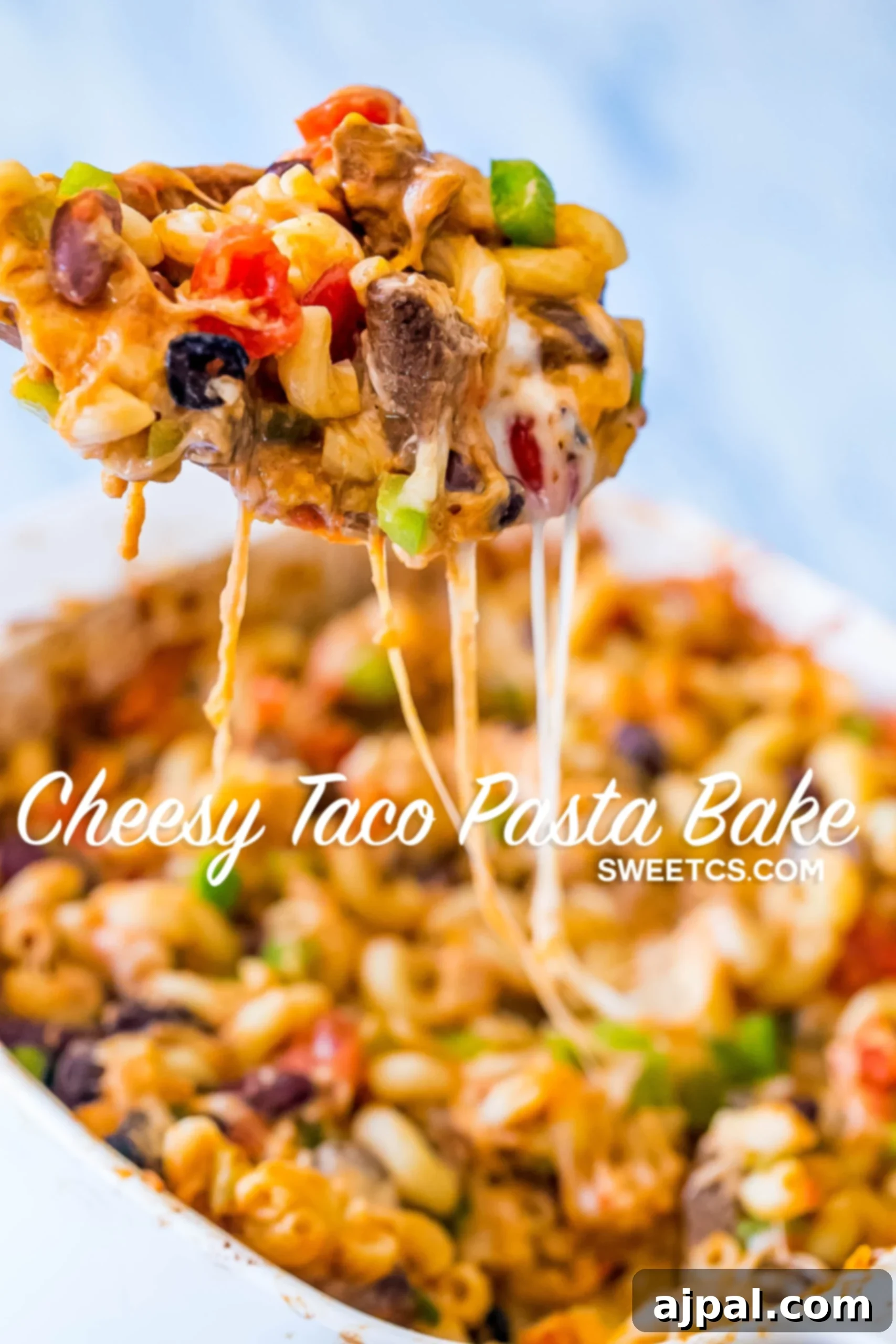 Side view of the Cheesy Taco Pasta Bake in a casserole dish before serving, highlighting its generous cheese topping and vibrant ingredients.