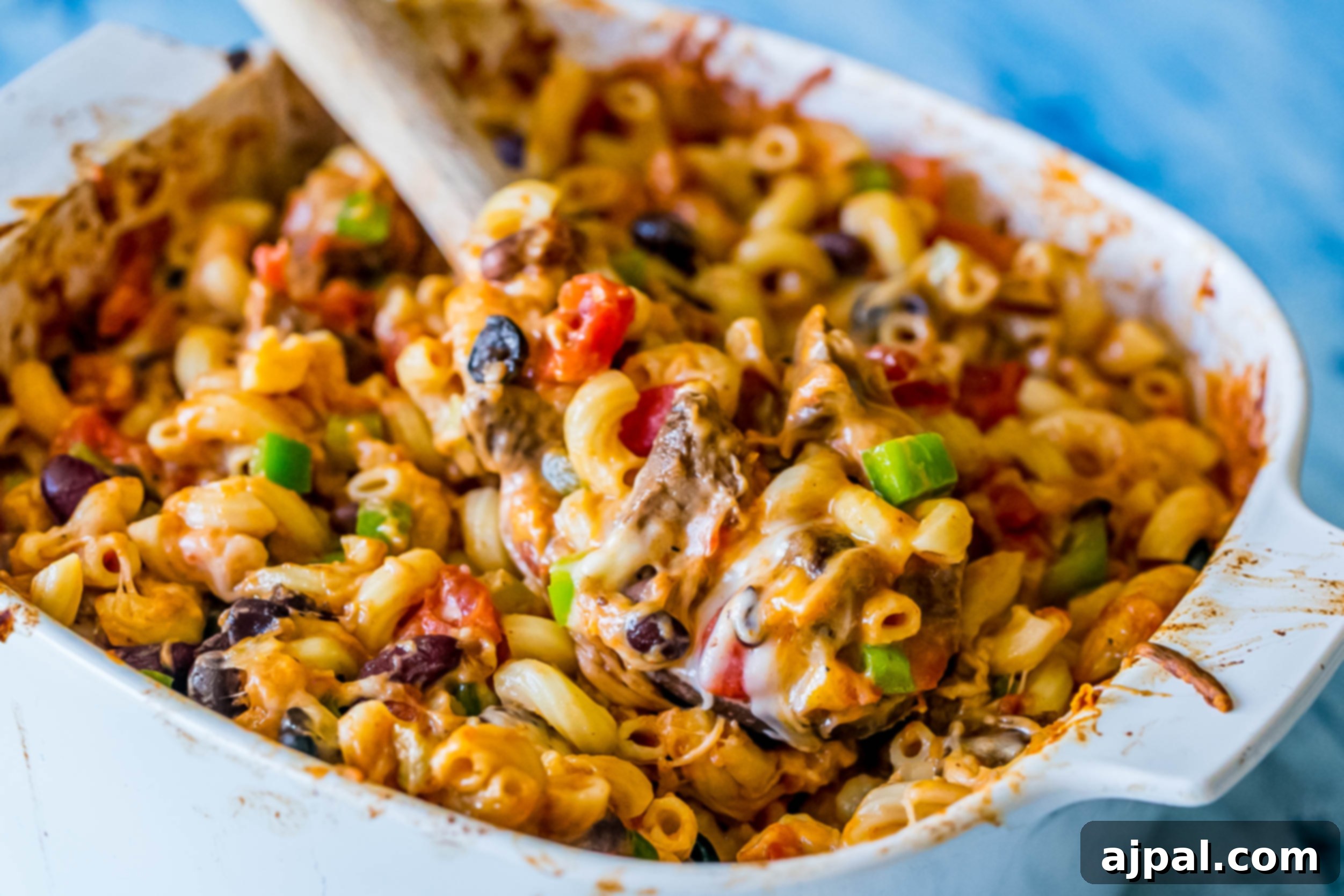 Another angle of the Cheesy Taco Pasta Bake, showing its depth and layers of cheese and ingredients in the baking dish.