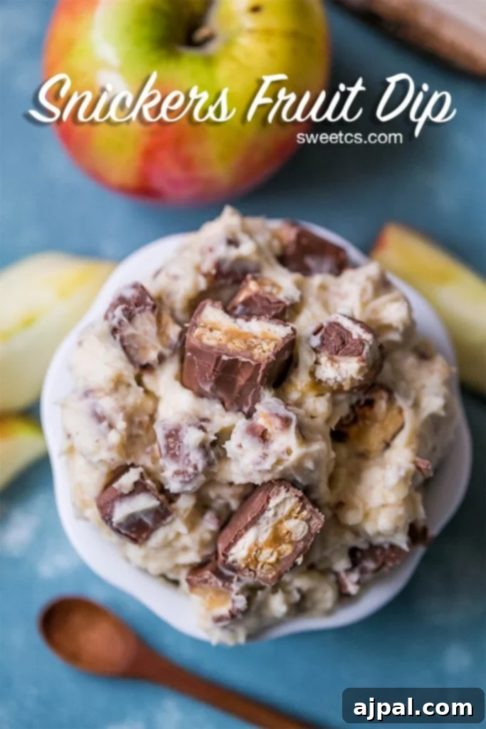 Creamy Snickers fruit dip with visible pieces of Snickers candy bar mixed in, served in a bowl.