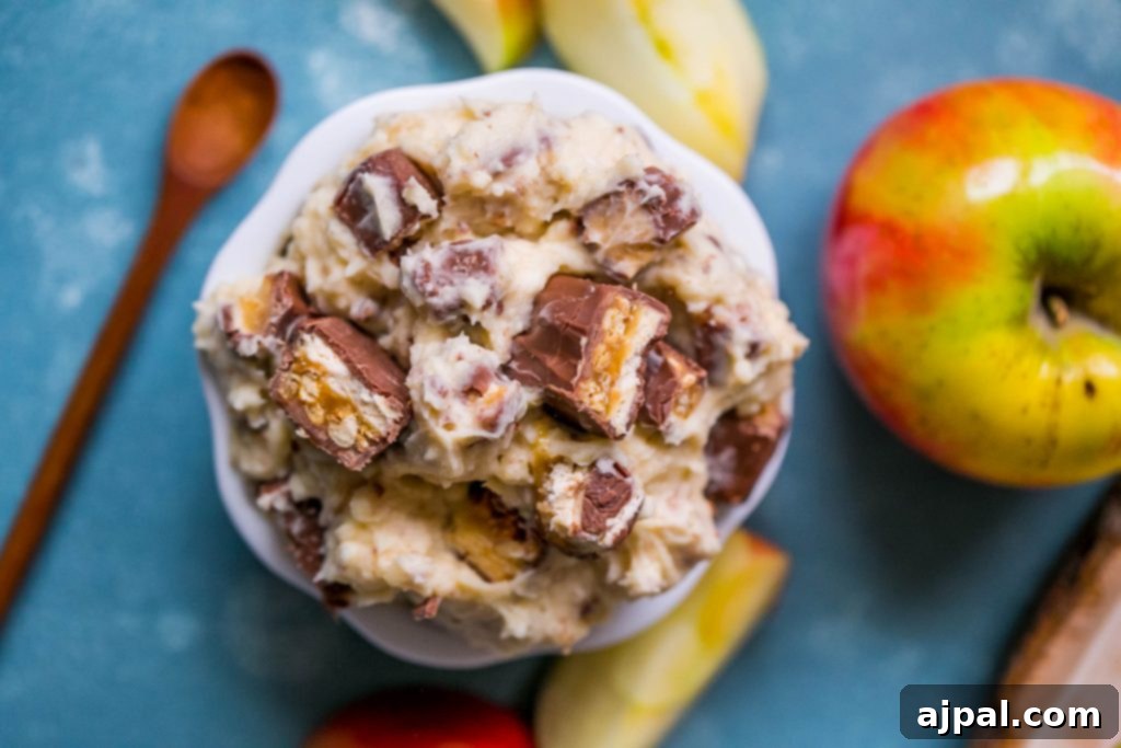 Close-up of Snickers fruit dip in a bowl, showing the creamy texture and small pieces of Snickers candy bar.
