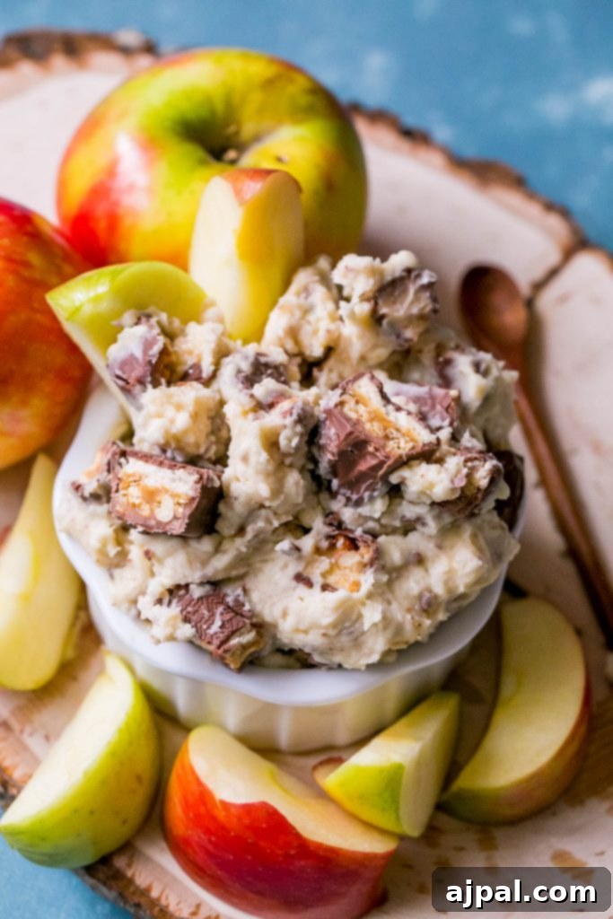 A large bowl of Snickers fruit dip, garnished with extra chopped Snickers, ready for a party.