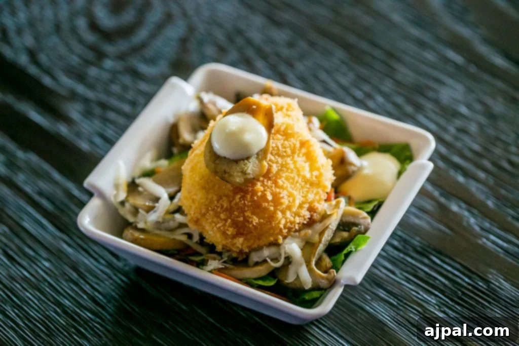 succulent crab cake atop a fresh salad with a drizzle of mayo