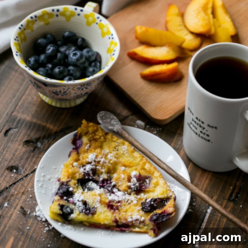 Another view of the puffed Dutch baby pancake with peaches and blueberries in the skillet