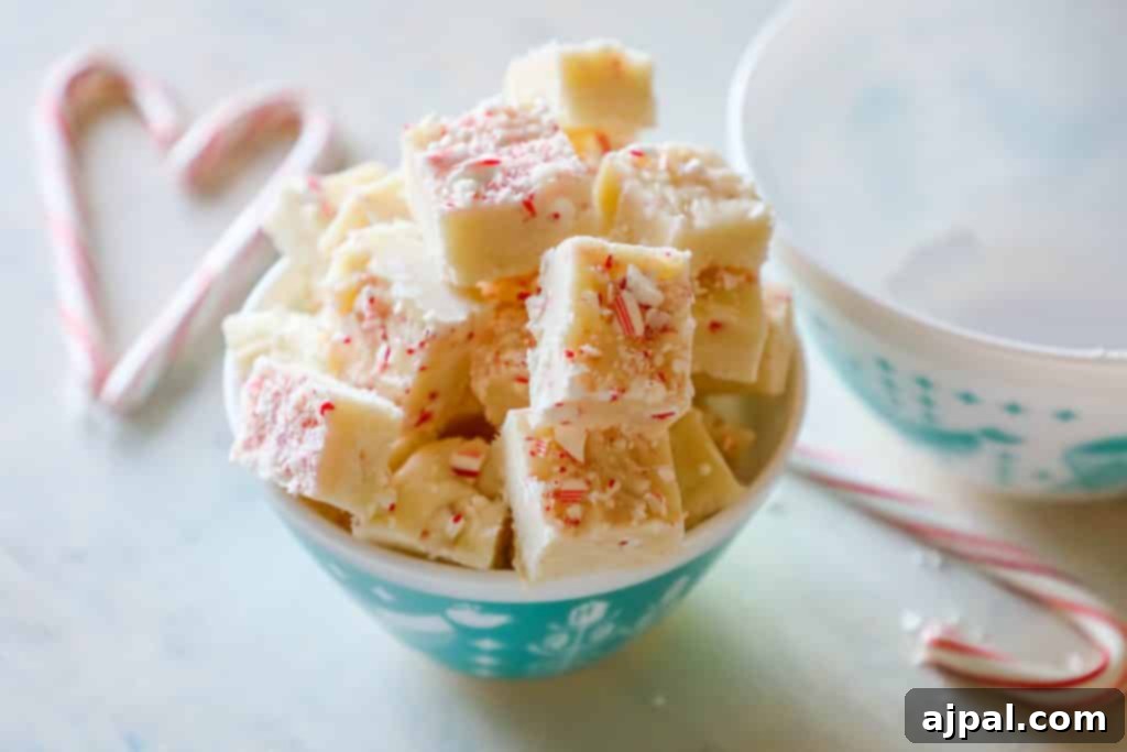 A large, uncut slab of candy cane cake fudge, highlighting its beautiful, smooth texture and the promise of a delightful holiday treat.