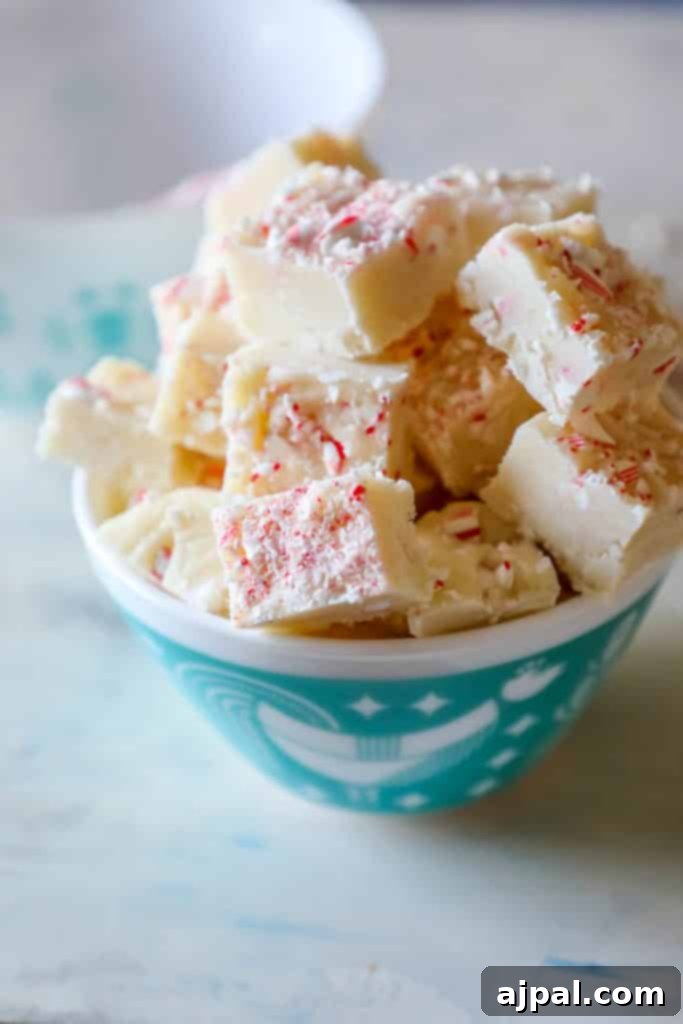 A festive tray of white chocolate peppermint bark fudge, perfect as an easy neighbor gift during the holidays.
