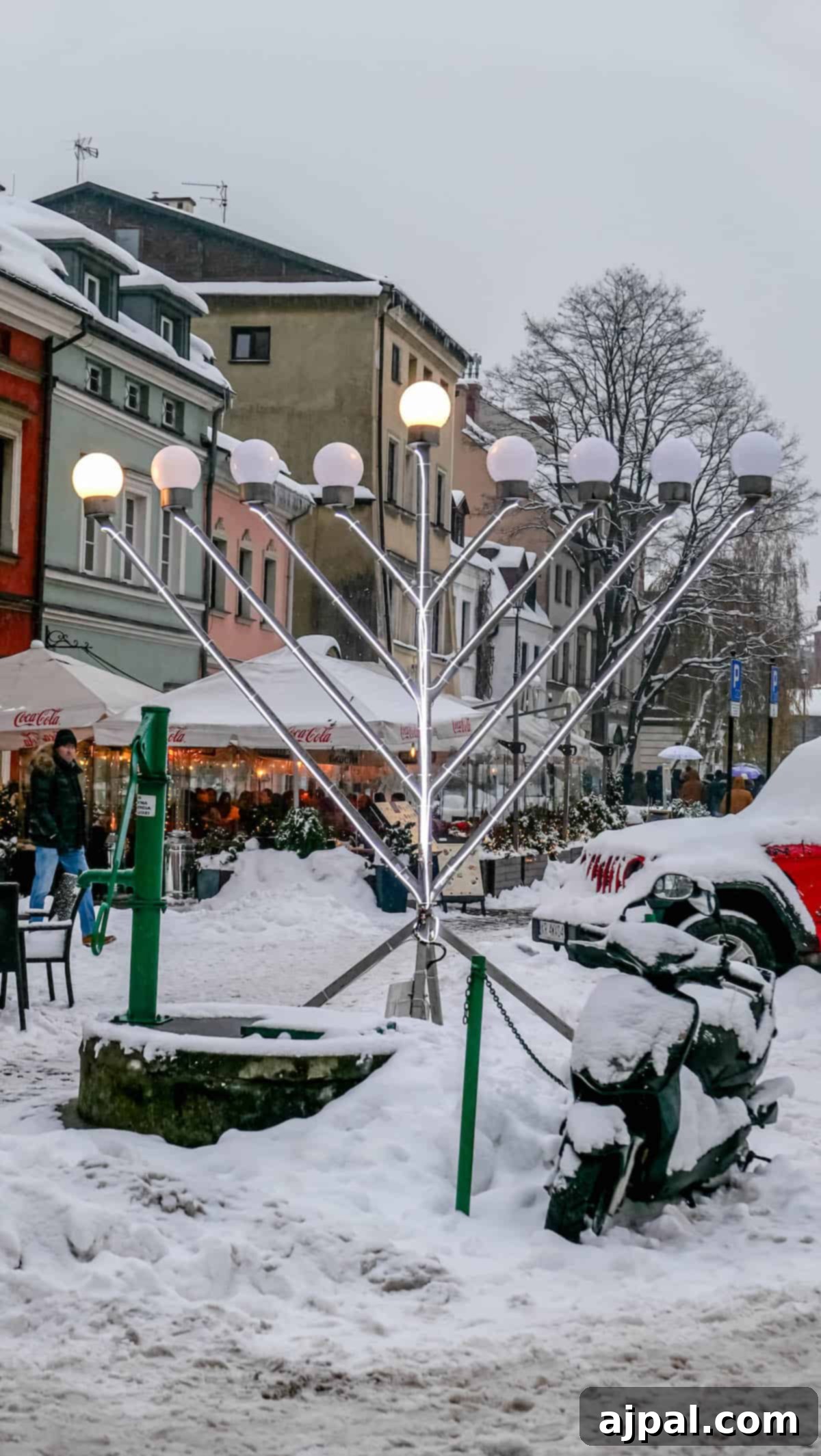 A Polish menorah in the middle of a snow covered street.