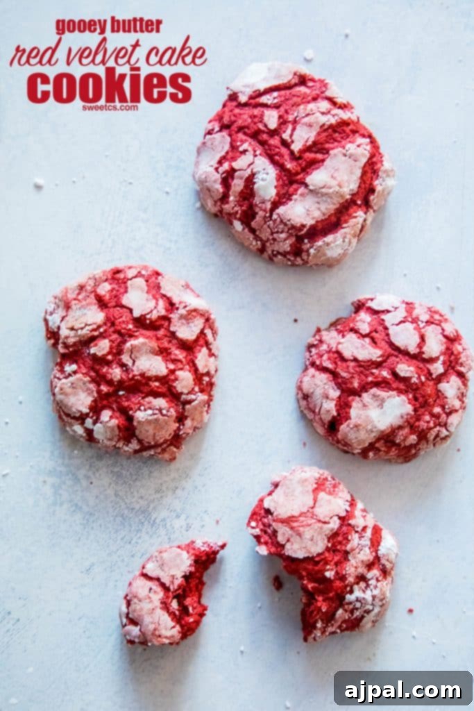 Gooey butter red velvet cake cookies with a bite taken out, showcasing their soft interior.
