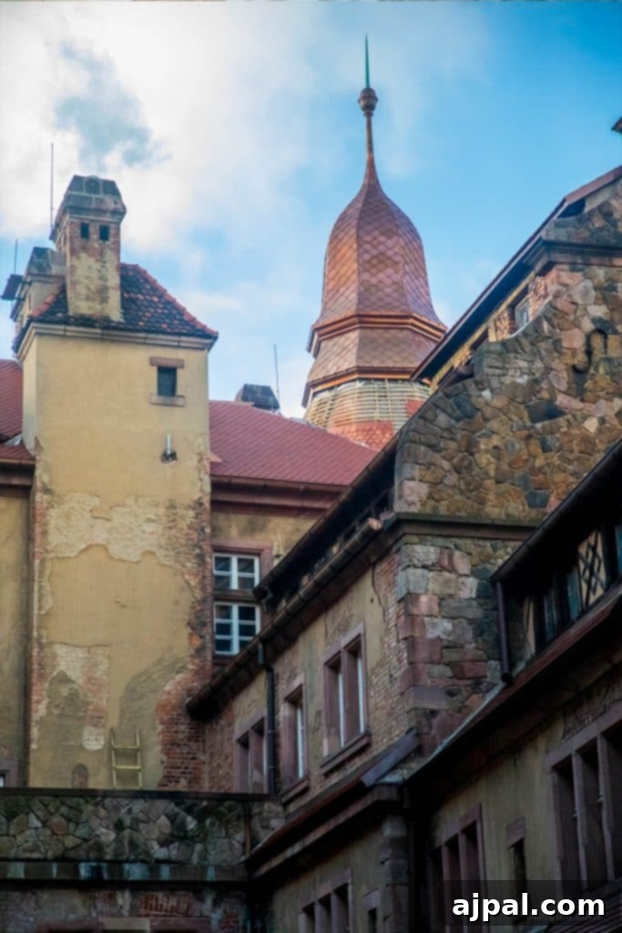 Ksiaz Castle Hotel 11 A view of Ksiaz Castle from within its grounds, featuring a distinctive clock tower.