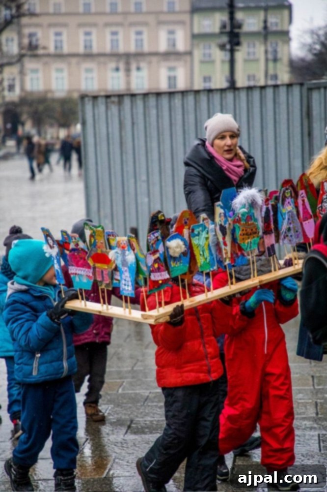 Children carrying traditional Polish cribs made from cardboard and foil, ready for the Krakow Crib Competition.