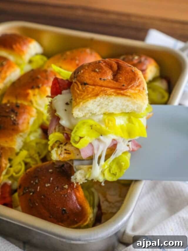 Game Day Feast: 12 Must-Try Dishes 13 A baking pan filled with golden-brown hot Italian sliders, topped with melted cheese and herbs, showcasing their ready-to-serve appeal for a party.