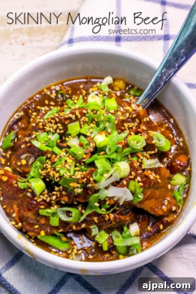 A steaming bowl of Skinny Mongolian Beef stew, garnished with vibrant green onions and sesame seeds, with a spoon nestled in the rich sauce. This healthy, savory dish is perfect for Instant Pot or slow cooker preparation.