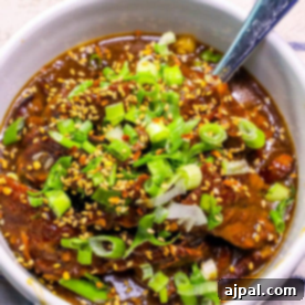 A bowl of skinny Mongolian beef stew with green onions and sesame seeds.