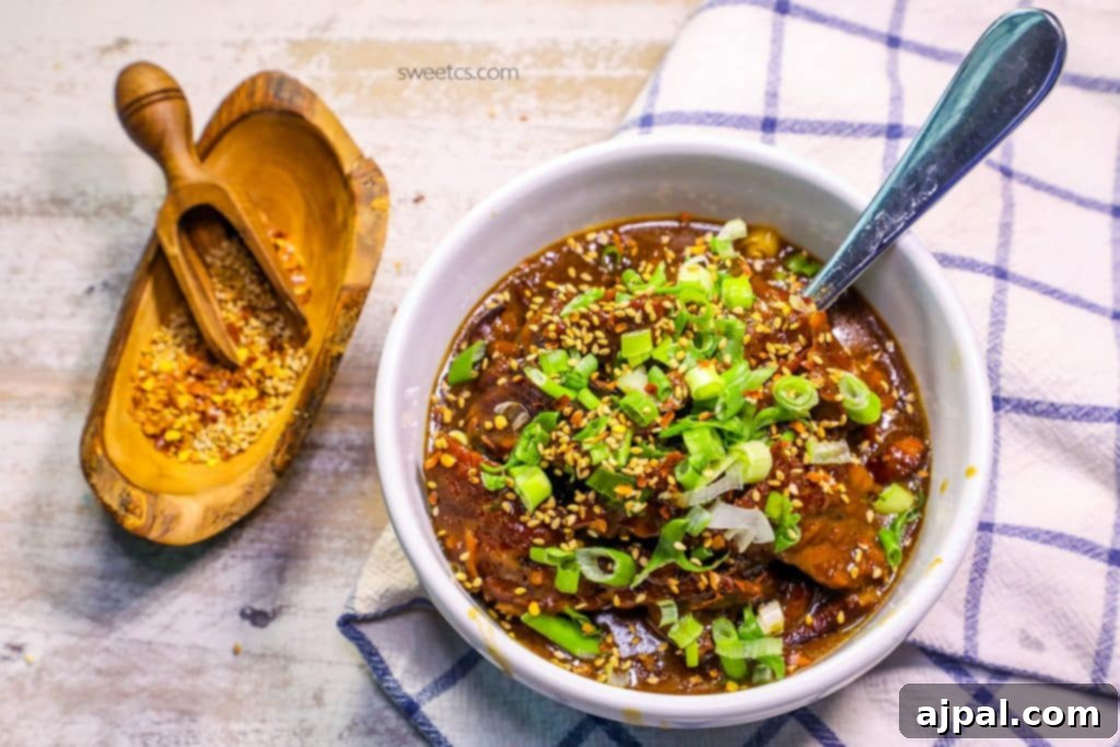 A beautifully presented bowl of Skinny Mongolian Beef stew, adorned with vibrant green onions and sesame seeds, with a spoon ready for tasting. The scene is completed with a rustic wooden bowl, spoon, and scattered spices nearby, emphasizing the natural flavors.