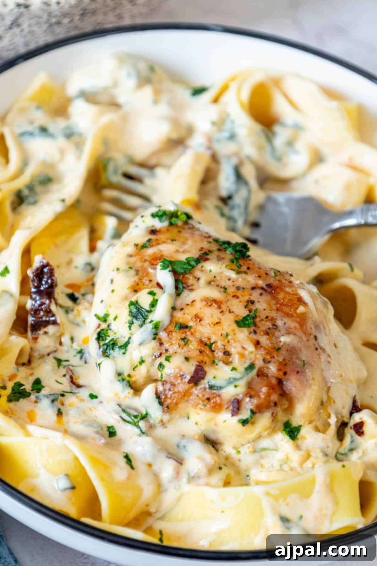 Decadent Creamy Tuscan Chicken Alfredo 3 A bowl of creamy Tuscan chicken pasta, ready to be enjoyed.
