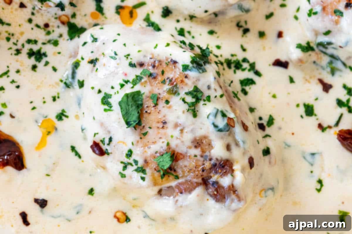 Decadent Creamy Tuscan Chicken Alfredo 9 Creamy tuscan chicken with chicken breasts in a creamy sauce, ready to be served.