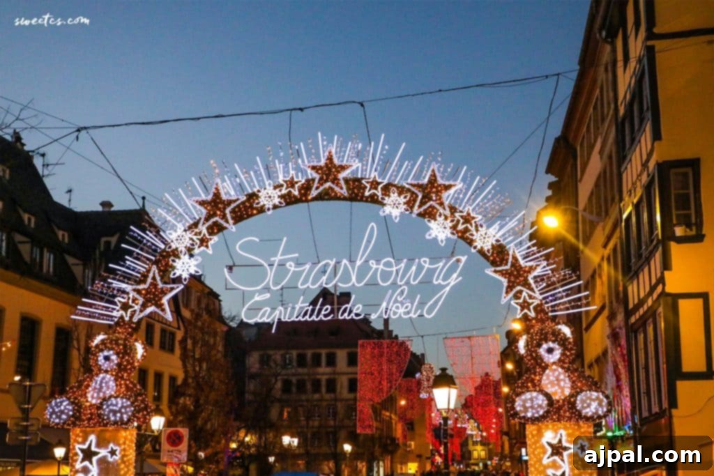 Strasbourg's Magical Christmas Markets 2 A majestic Christmas arch, adorned with glowing lights, beckons visitors into the festive streets of Strasbourg, France.
