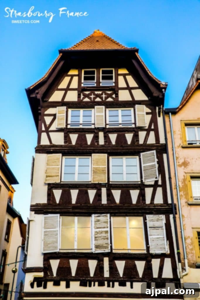 Strasbourg's Magical Christmas Markets 3 A charming half-timbered building with traditional shutters, exuding the quintessential Alsatian architectural style.