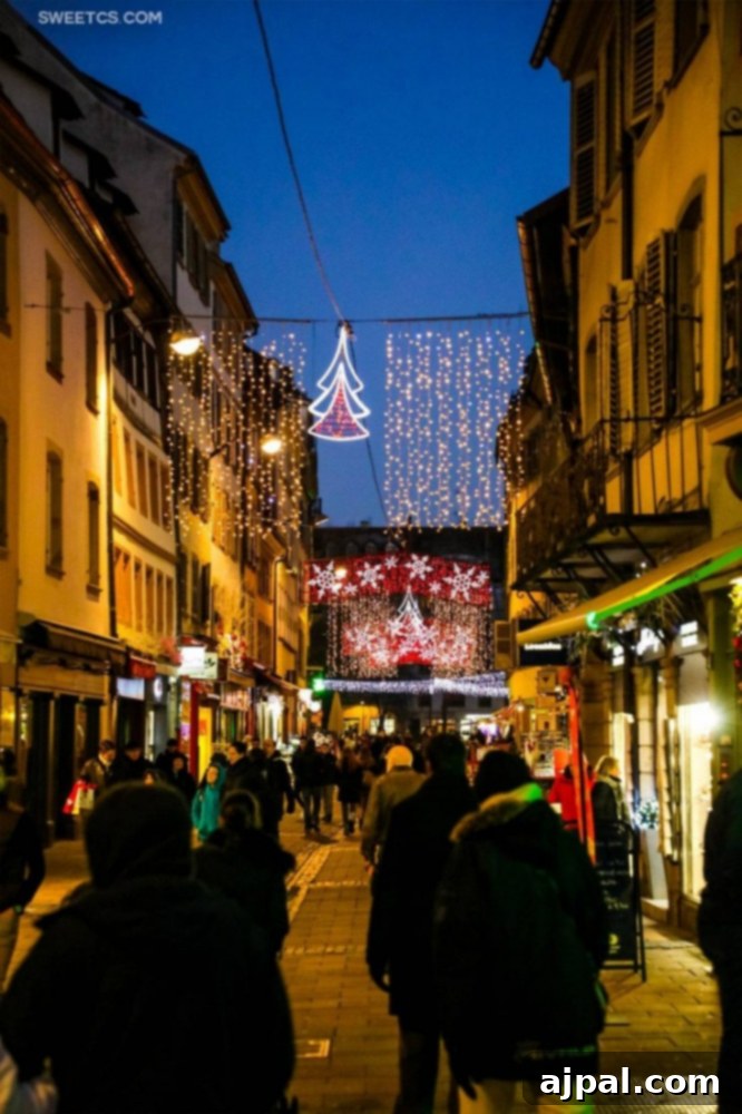 Strasbourg's Magical Christmas Markets 7 People strolling down a beautifully decorated street in Strasbourg, France, surrounded by vibrant Christmas lights.