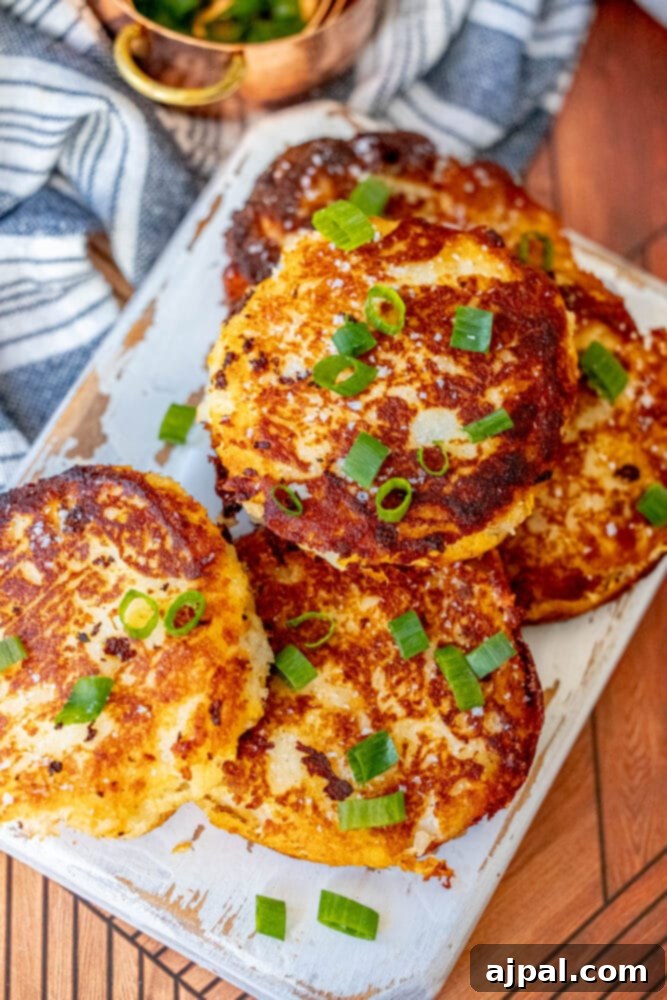 Crispy Irish potato pancakes garnished with fresh green onions on a rustic cutting board.