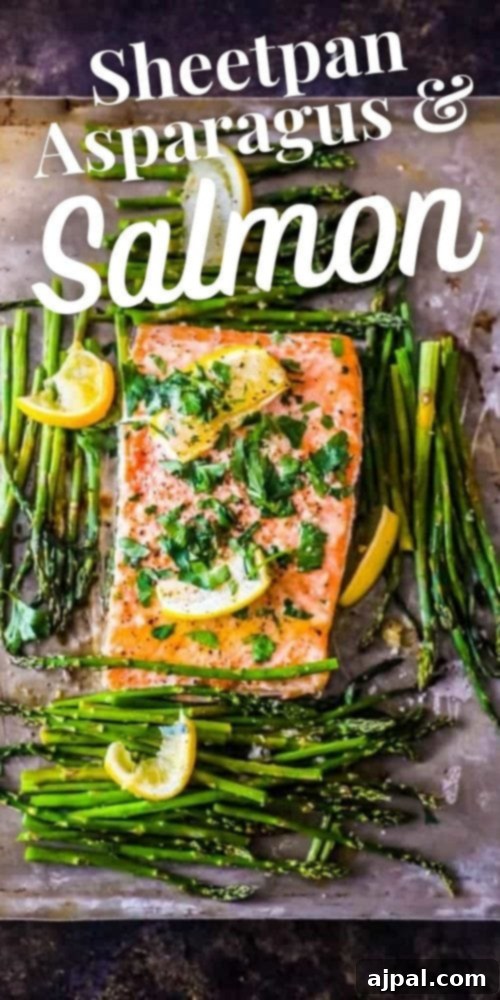 Zesty Sheet Pan Lemon Garlic Salmon and Asparagus 12 Picture of perfectly cooked salmon and asparagus on a baking sheet, adorned with fresh lemon slices and a sprinkle of parsley.