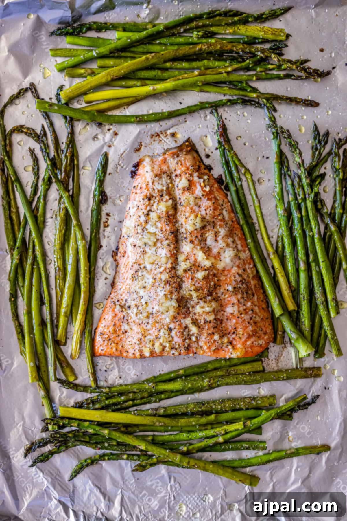 Zesty Sheet Pan Lemon Garlic Salmon and Asparagus 7 Baked salmon fillet and asparagus spears on a foil-lined baking sheet, perfectly seasoned and cooked, showcasing an easy salmon and asparagus recipe ideal for weeknight dinners.