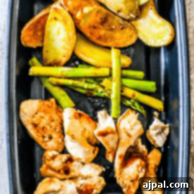 Instant pot balsamic chicken and vegetables bowls with roasted potatoes and asparagus on a black plate.