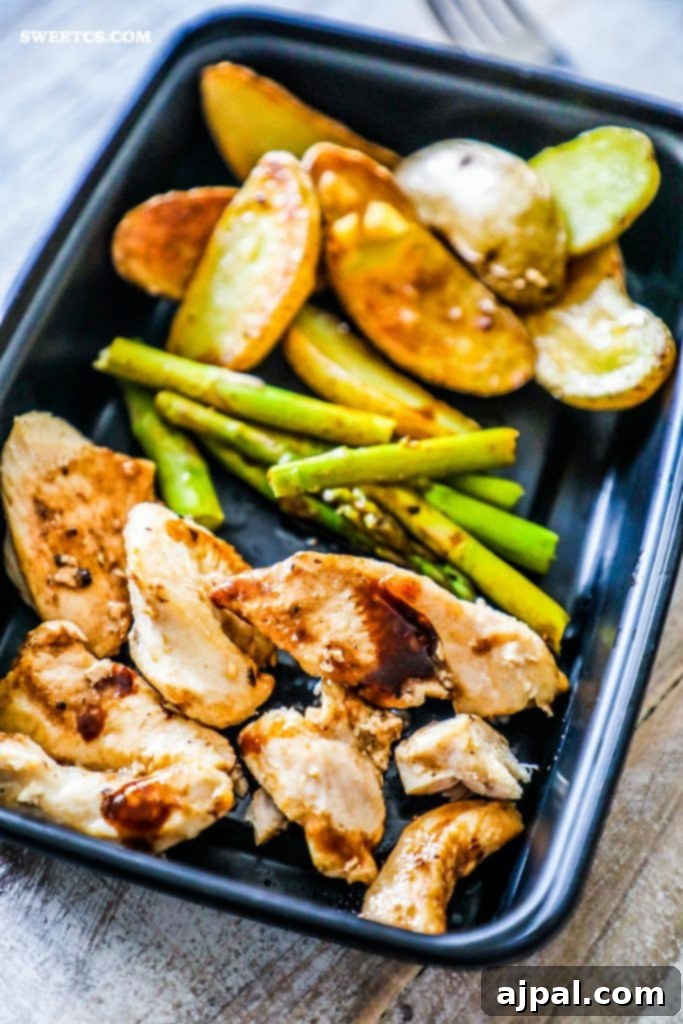 Close-up of a perfectly portioned Instant Pot Balsamic Chicken and Vegetables meal prep bowl with chicken, asparagus, and potatoes.