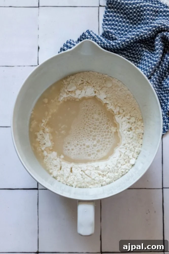 picture of water poured into the middle of well in flour in mixing bowl 