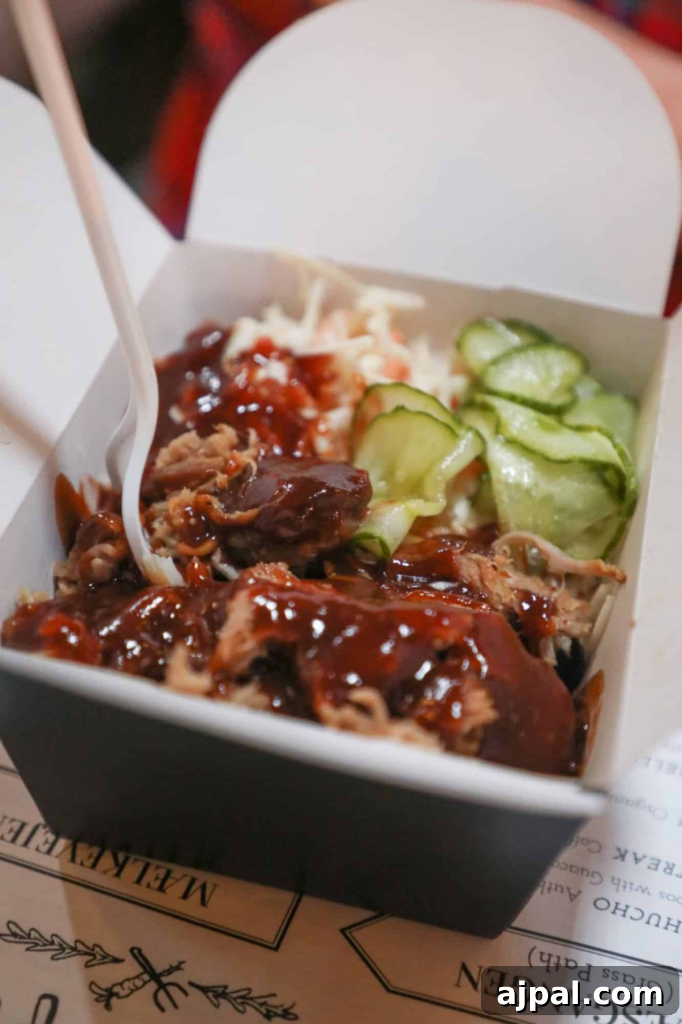 Paper Island Copenhagen Urban Oasis 9 A close-up of delicious BBQ pulled duck fries in a box, topped with a creamy sauce and pickled onions, ready to be enjoyed at Paper Island.