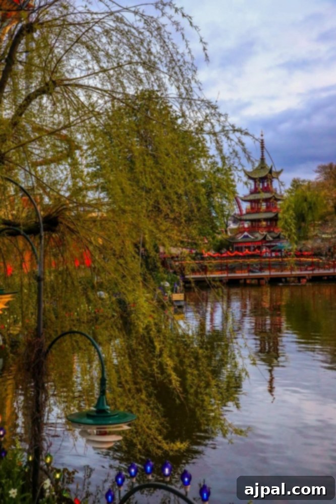 Tivoli Gardens Copenhagen Wonderland 7 A serene pagoda by a tranquil pond in Tivoli Gardens, Copenhagen, offering a moment of peace.