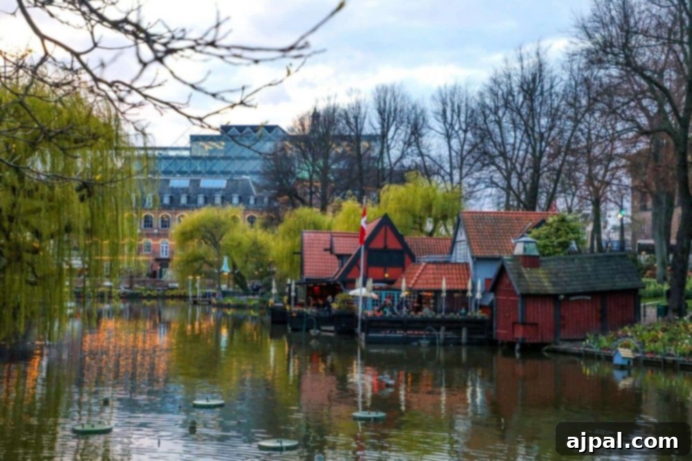 Tivoli Gardens Copenhagen Wonderland 8 A picturesque canal winding through Tivoli Gardens, Copenhagen, with charming houses and lush trees.